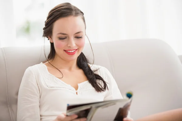 Mooie brunette lezing tijdschrift op de Bank — Stockfoto