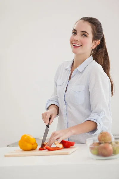 Pretty brunette slicing up peppers — Stock Photo, Image