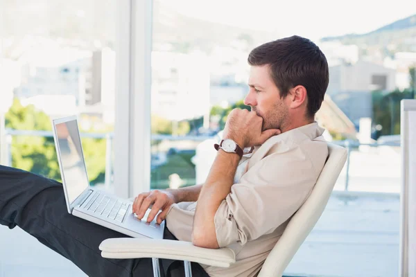 Homem de negócios relaxado com um laptop — Fotografia de Stock