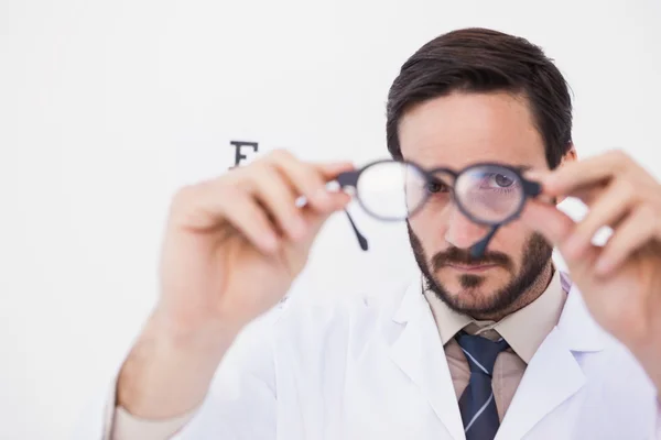 Doctor wearing lab coat looking through eyeglasses — Stock Photo, Image