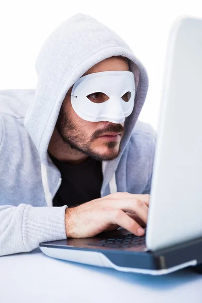 Homem usando máscara ao hackear em laptop — Fotografia de Stock