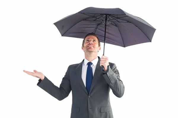 Affärsman skyddande under svart paraply — Stockfoto