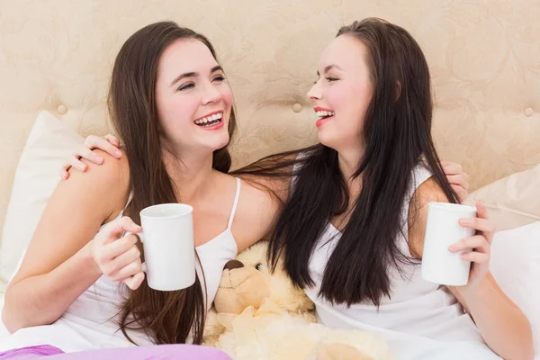 Amigos bonitos tomando café na cama — Fotografia de Stock