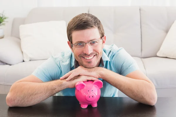 Sorrindo homem com um banco porquinho — Fotografia de Stock