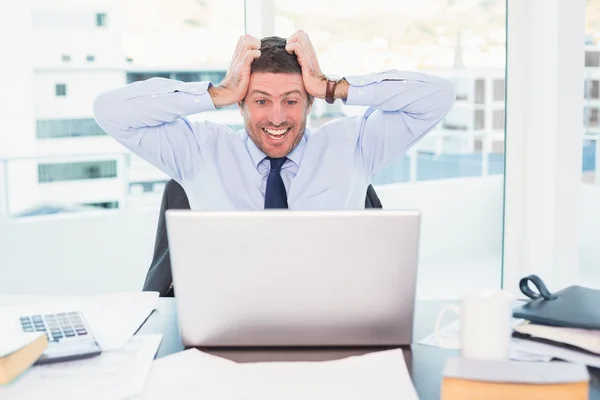 Un hombre de negocios sonriente tomando su cabeza —  Fotos de Stock