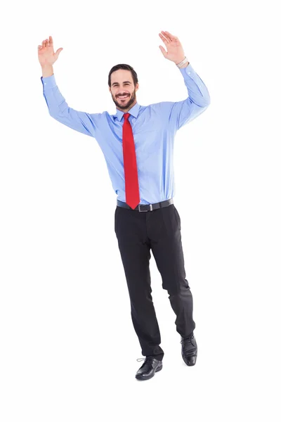Улыбающийся бизнесмен шагает с поднятыми руками — стоковое фото