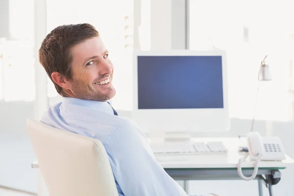 Lachende zakenman zit aan zijn Bureau — Stockfoto