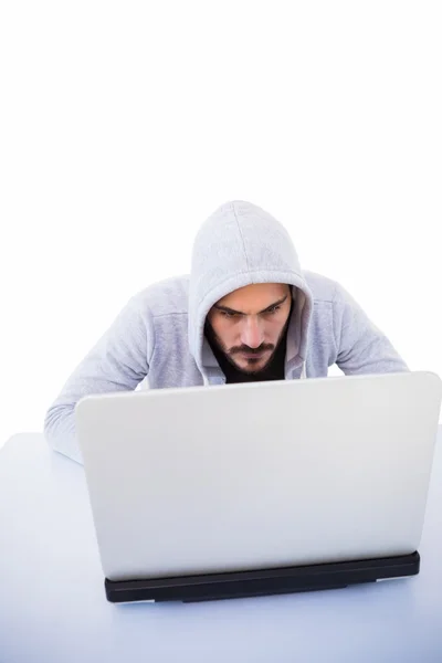 Serious burglar hacking into laptop — Stock Photo, Image