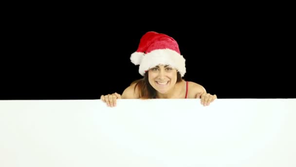 Beauty brunette in santa hat showing white poster — Stock Video