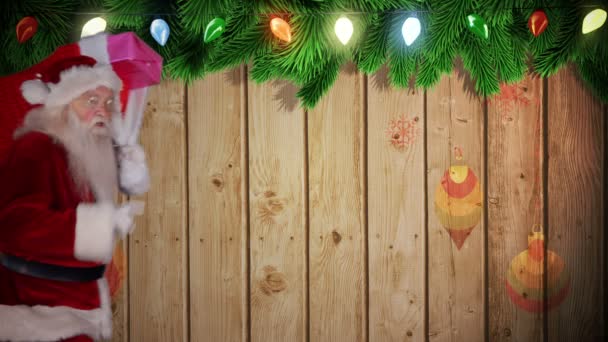 Babbo Natale che porta sacco di regali sullo sfondo di legno festivo — Video Stock