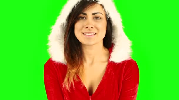 Bonita morena en santa hat soplando sobre las manos — Vídeo de stock