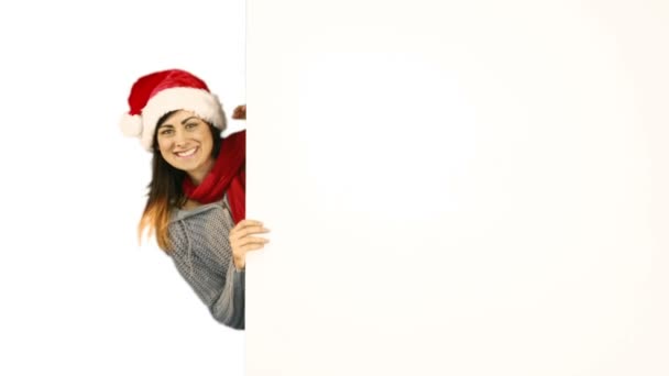 Krása bruneta v santa hat ukazující bílý plakát — Stock video