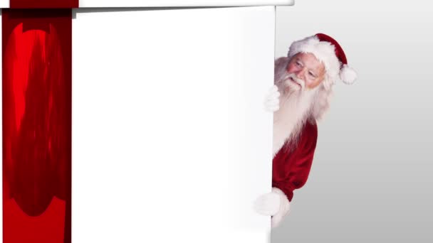 Santa peeking around a christmas gift — Stock Video