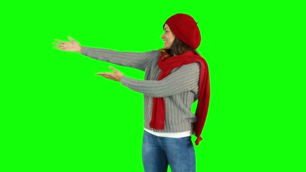 Půvabná brunetka v santa hat chůzi a prezentace s rukou — Stock video