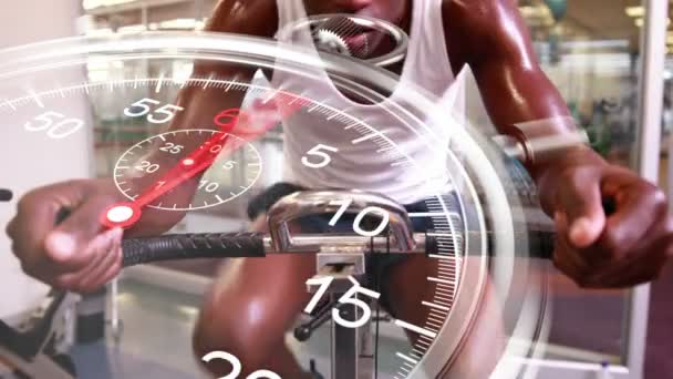 Stopwatch graphic over man using exercise bike — Stock Video