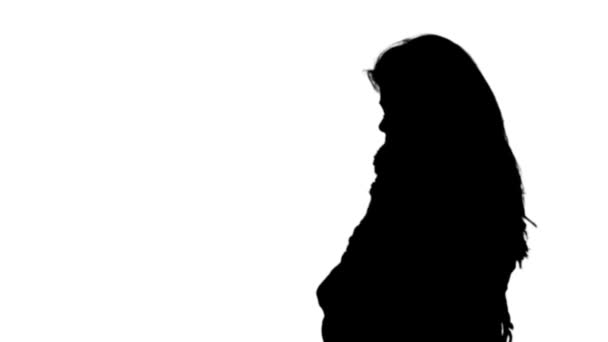 Женщина дрожит в черном силуэте — стоковое видео