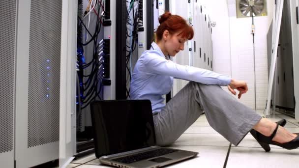 Stressed technician sitting on floor beside open server — Stock Video