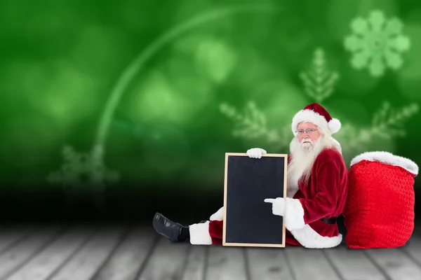 Санта сидит, опираясь на свою сумку — стоковое фото