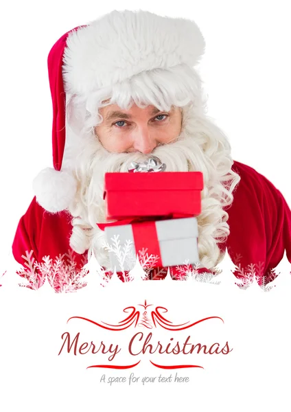 Smiling santa holding pile of gifts — Stock Photo, Image