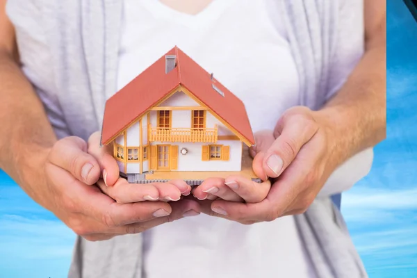 Casal segurando casa modelo — Fotografia de Stock