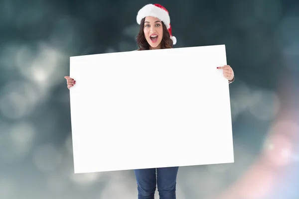 Pretty brunette in santa hat pointing — Stock Photo, Image