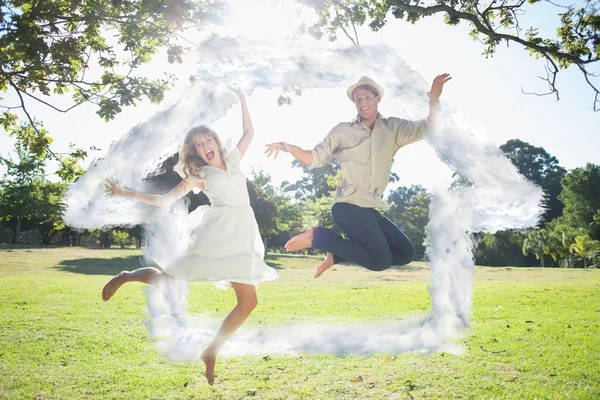 Cute couple jumping in the park together — Stock Photo, Image