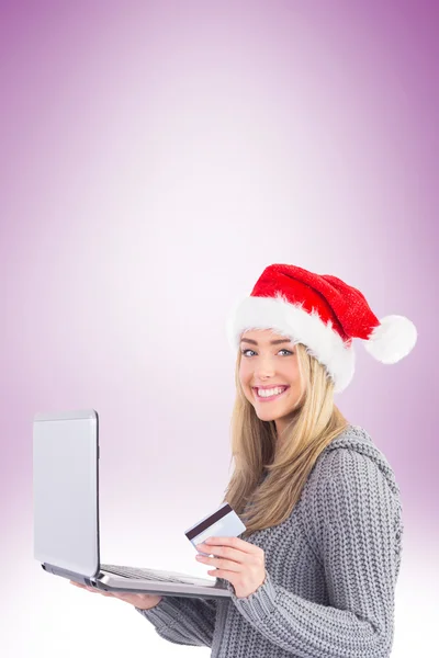 Feestelijke blonde online winkelen met laptop — Stockfoto