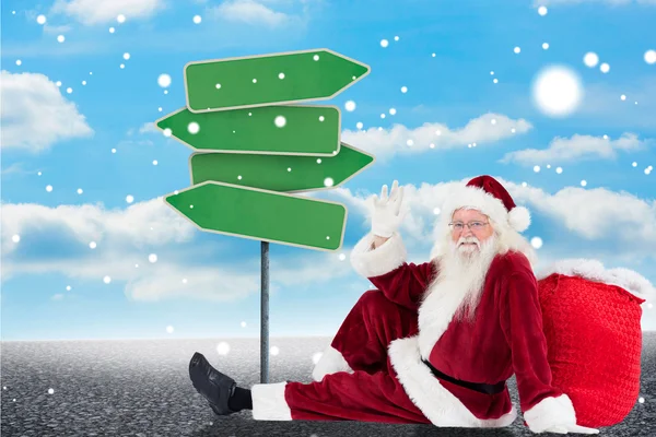 Santa zit leaned op zijn zak en golven — Stockfoto