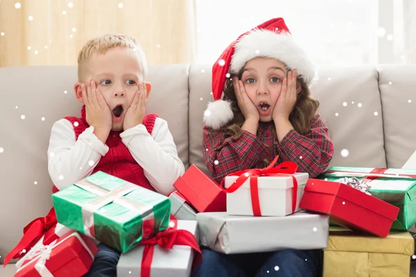 Festliche Geschwister umgeben von Geschenken — Stockfoto