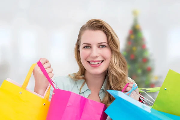 Złożony obraz ładna kobieta uśmiechając się do kamery z shopp — Zdjęcie stockowe