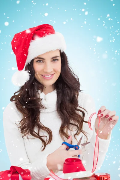 Brunette in santa hat packing gifts — Stock Photo, Image