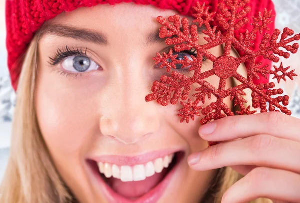 Loira feliz segurando floco de neve vermelho — Fotografia de Stock