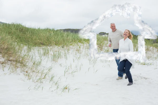 Веселая пожилая пара, гуляющая по пляжу — стоковое фото