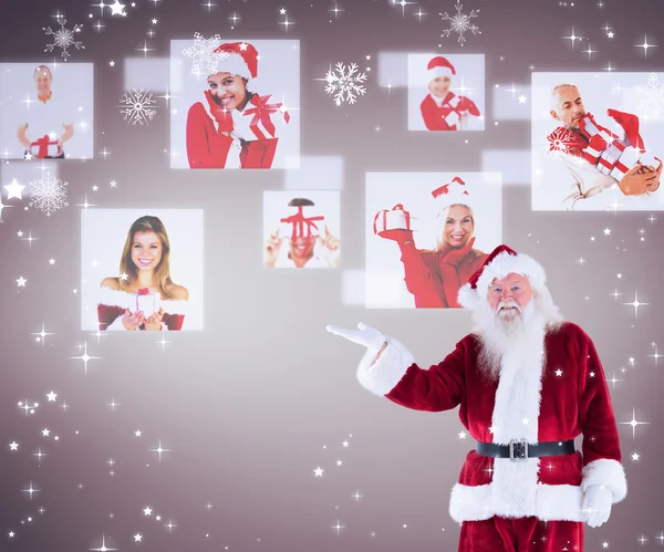 Санта-Клаус что-то показывает на камеру — стоковое фото