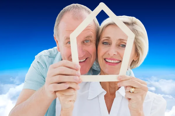 Feliz casal mais velho segurando a forma da casa — Fotografia de Stock