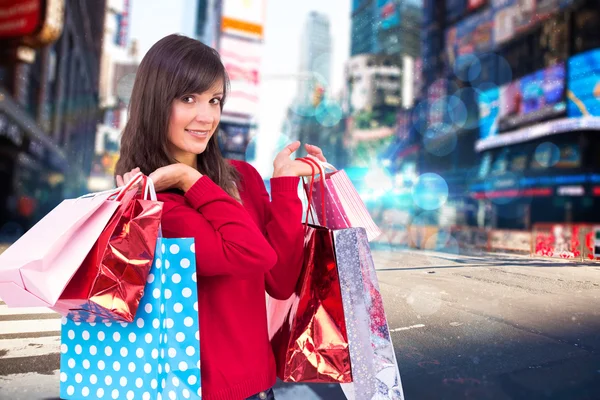 Sonriente morena sosteniendo bolsas de compras —  Fotos de Stock