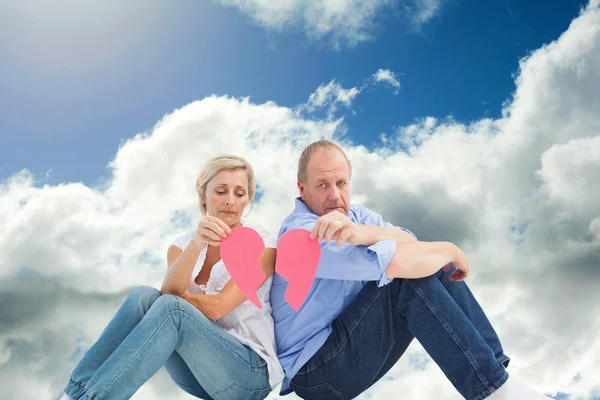 Sad mature couple holding a broken heart — Stock Photo, Image