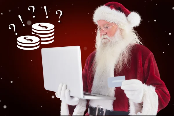 Santa platí kreditní kartou na notebooku — Stock fotografie