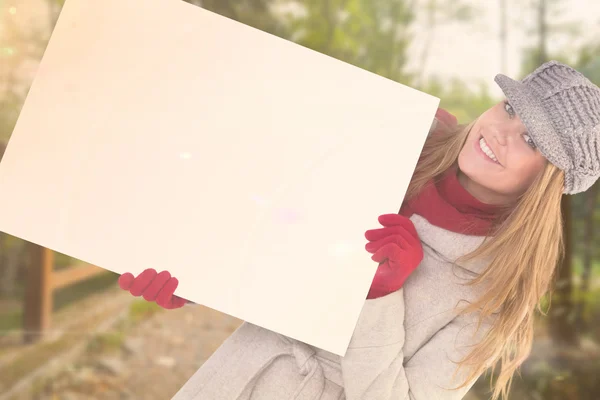 Felice bionda in abiti invernali mostrando carta — Foto Stock