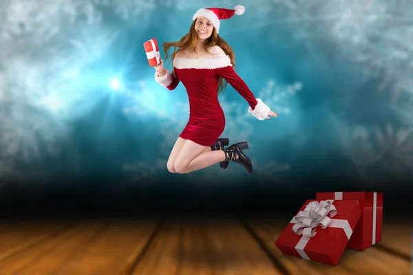 Festive redhead jumping with gift — Stock Photo, Image