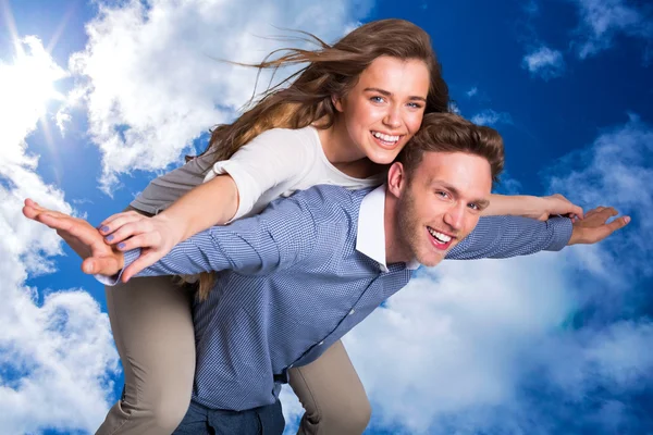 Sorridente giovane uomo che trasporta donna — Foto Stock