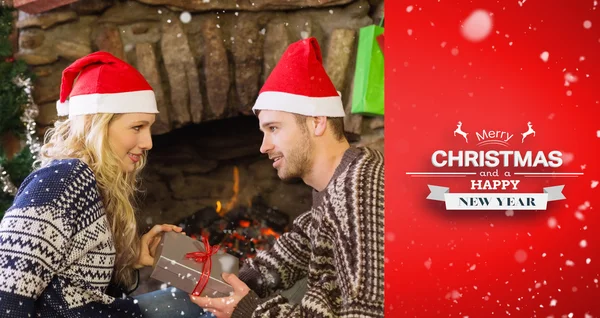 Hombre mujer regalando delante de la chimenea encendida — Foto de Stock