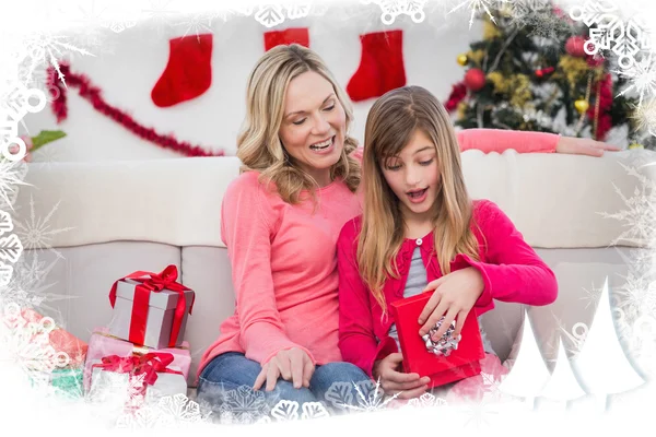 Girl opening gift with mother — Stock Photo, Image