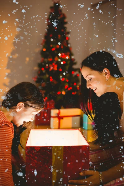 Feestelijke moeder en dochter openen een gloeiende — Stockfoto