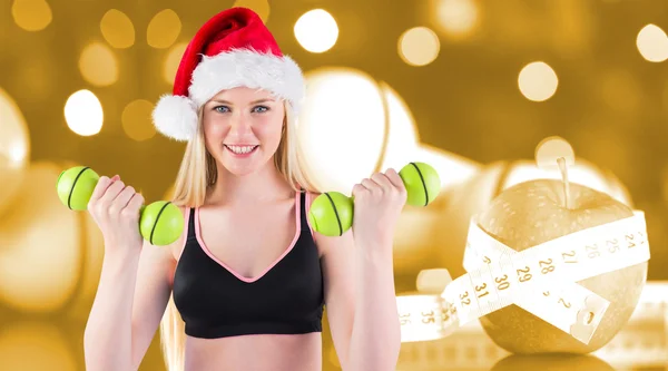 Composite image of festive fit blonde smiling at camera — Stock Photo, Image