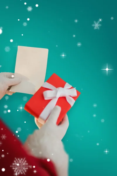 Father christmas holding gift — Stock Photo, Image