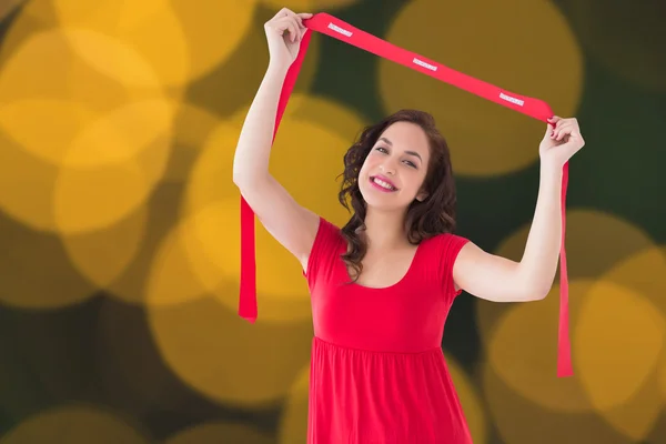 Samengestelde afbeelding van stijlvolle brunette in rode jurk bedrijf sjaal — Stockfoto