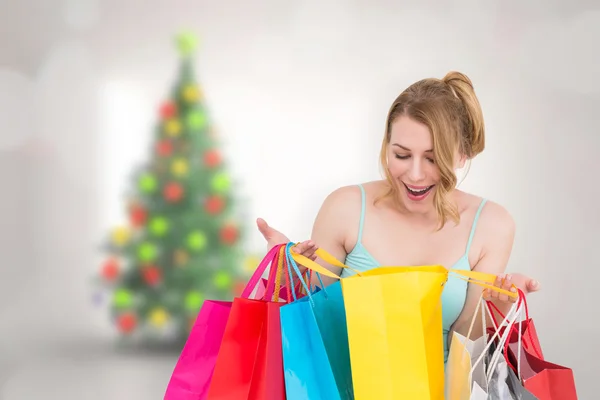 Immagine composita di donna eccitata guardando molte borse della spesa — Foto Stock