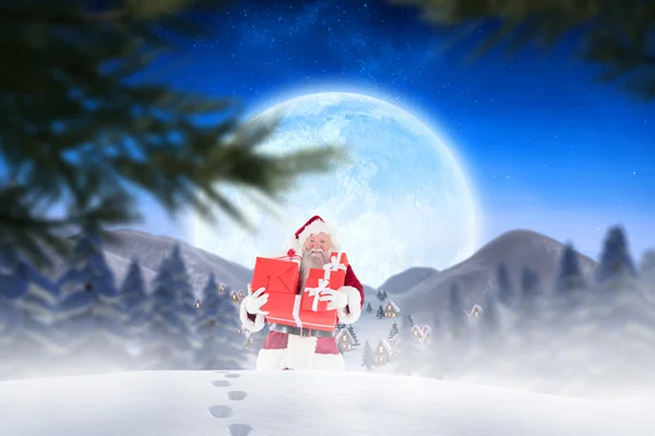 Santa hediyeler karda taşıyan — Stok fotoğraf