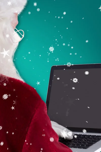 Weihnachtsmann nutzt Laptop — Stockfoto